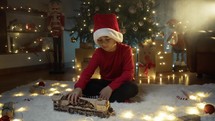 boy with Christmas hat playing with toy train 