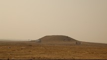 men walking down a hill in a desert 