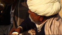 A man drinking form a cup in the desert
