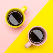 Flat lay top view of a two coffee cups with pink and yellow
