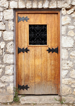 Old wooden door in the stone wall