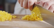 Slow motion close up of a chef knife slicing a yellow bell pepper