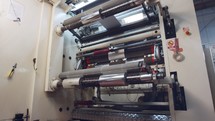 Large industrial printing machine splicing rolls of shiny paper