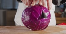 Slow motion close up of a chef knife slicing a Red cabbage
