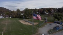 Drone over fall foliage and small town football field