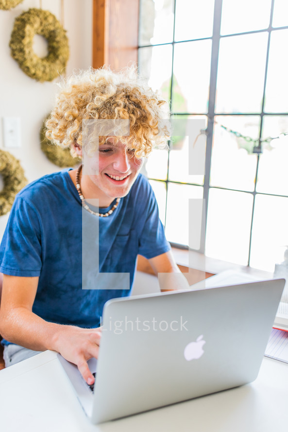 teen boy on a computer for virtual learning 