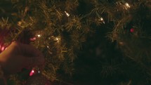 Christmas Tree Shoot - Woman hangs Christmas bulb on tree