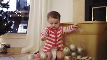toddler playing with Christmas decorations 