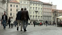 people walking in a courtyard in Trieste, Italy