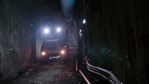 Large construction trucks working inside a tunnel
