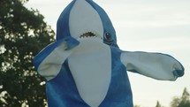 a woman dancing in a shark costume 