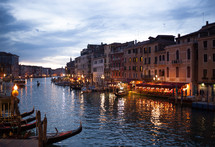 Night view of Grand Canal from Rialto bridge with gondolas in Venice. Italy