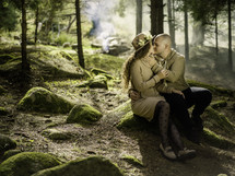 Couple kissing on moss covered rocks