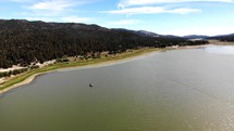 Aerial Shot Flying Across Big Bear Lake with a Boat in View