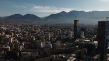 Skyscrapers and buildings in Tirana Albania, aerial drone view with mountains and clouds in the background