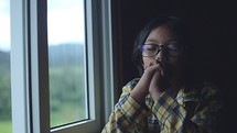 a girl praying by a window 