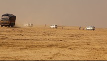 vehicles driving in desert sand 