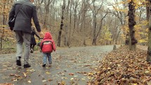 family walking on a fall path with a stroller 