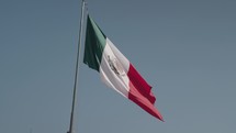 Slow Motion of The National Flag of Mexico on Blue Sky - Vertical Tricolor of Green, White, and Red with the National Coat of Arms Charged in the Center of the White Stripe