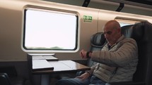 Elderly man is traveling by train