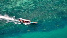 Small boat drives on crystal clear blue water to exotic island. Boat trip. Long Tail Boat. 