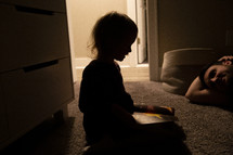 silhoutte of a child reading a book 