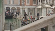 The atmosphere of narrow canals in the city of Venice, with many bridges, boats and gondola.