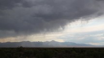 A rain storm over mountains in the desert.