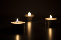 votive candles and candlelight in darkness 