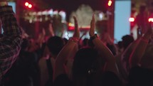 Unrecognizable People Crowd Dance and Hands Up at Evening Live Music Concert on Stage at Festival with Laser and Light in Slow Motion