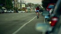 man riding a bicycle down a busy street 