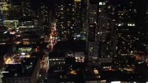 Aerial night drone shot of busy, vibrant downtown Toronto. View around the illuminated John Street. Drone flying over modern high-rises around the financial district with moderate traffic.