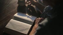 a man sitting at a table reading a Bible 