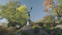 The Falconer Sculpture a man reaching upwards to release his hunting bird and Central Park Tower Manhattan, New York City, USA