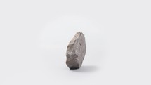 Spinning rock on white background