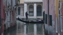 The atmosphere of narrow canals in the city of Venice, with many bridges and small boats parked.