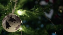 White ball hanging and moving on a christmas tree 