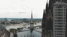 Pan out of the Cologne Cathedral during it's renovation construction revealing the landscape of Cologne, Germany.