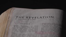 Light revealing a Bible and the book of Revelation