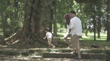 Portrait of Small and Happy Asian Family Enjoying Activities at The Park - Father, Mother and Child in Slow Motion