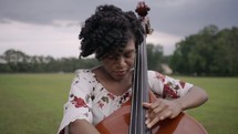 woman playing a cello outdoors 
