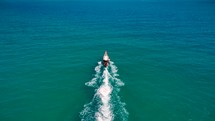 Small boat drives on crystal clear blue water to exotic island. Boat trip. Long Tail Boat. 