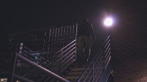 a man walking up steps at night 