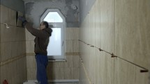 a man tiling a room 