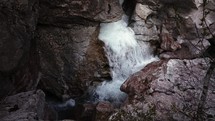 Scenic waterfall cascading through rocky mountains in slow motion