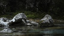 Calm mountain river flowing through rocks in slow motion