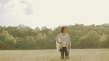 carefree woman walking through a field 