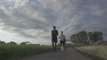 Three healthy active Asian Indonesian Men Running in Slow Motion on Jogging Track During Sunset - Bali Indonesia