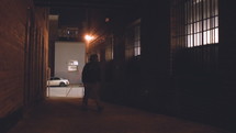 a man walking down a dark alley at night 