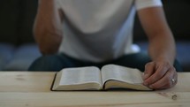a man turning the pages of a Bible 